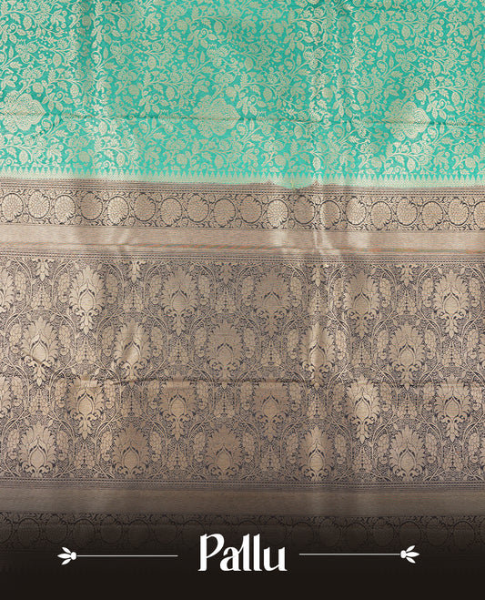 Aqua green colour semi silk brocade saree featuring intricate Gold Floral kodi patterns across the body, complemented by a contract dark blue colour woven border and pallu, paired with a matching blouse.
