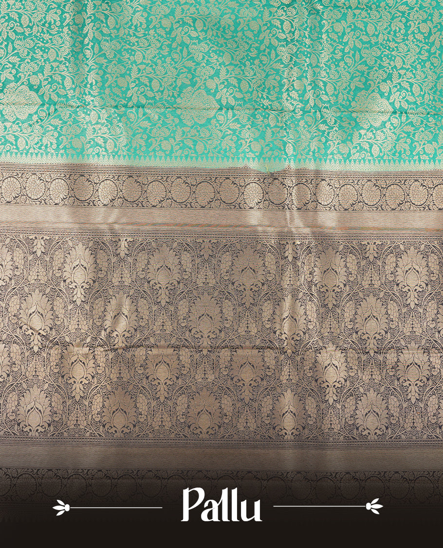 Aqua green colour semi silk brocade saree featuring intricate Gold Floral kodi patterns across the body, complemented by a contract dark blue colour woven border and pallu, paired with a matching blouse.