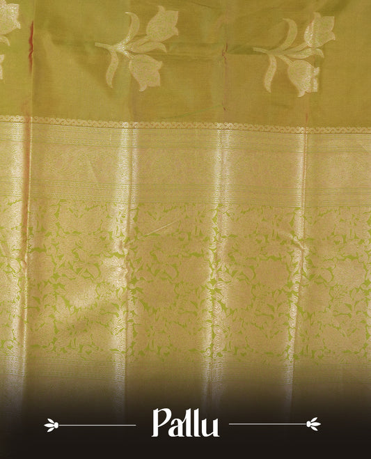 Olive Green colour semi silk saree adorned with floral motifs on the body, complemented by a shimmering golden zari-woven pallu and border, and paired with a matching blouse