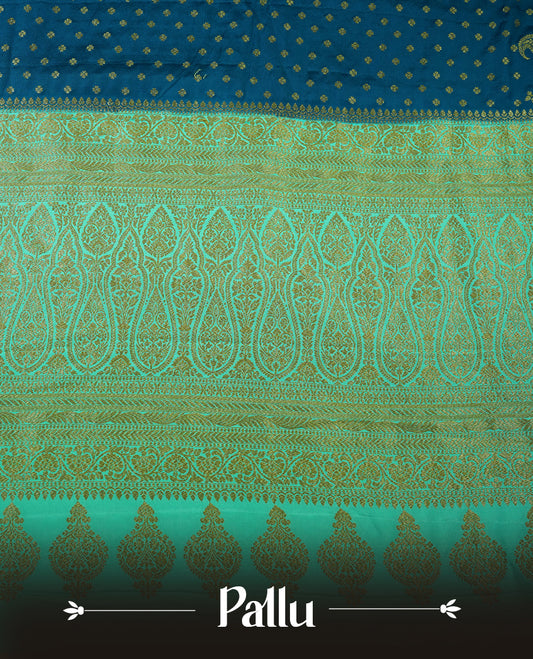 Dark Blue colour pure Banarasi georgette saree featuring gold zari Flower Motifs all over the body, complemented by an contrast sky blue dye colour with gold zari Floral Kodi Worked border and pallu, with matching blouse.