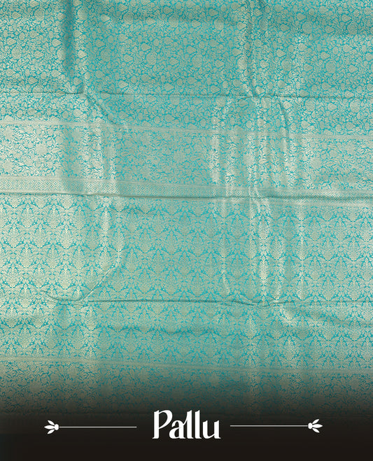 Aqua blue colour semi silk brocade saree featuring intricate Gold Floral kodi patterns across the body, complemented by a rich self colour woven border and pallu, paired with a matching blouse.