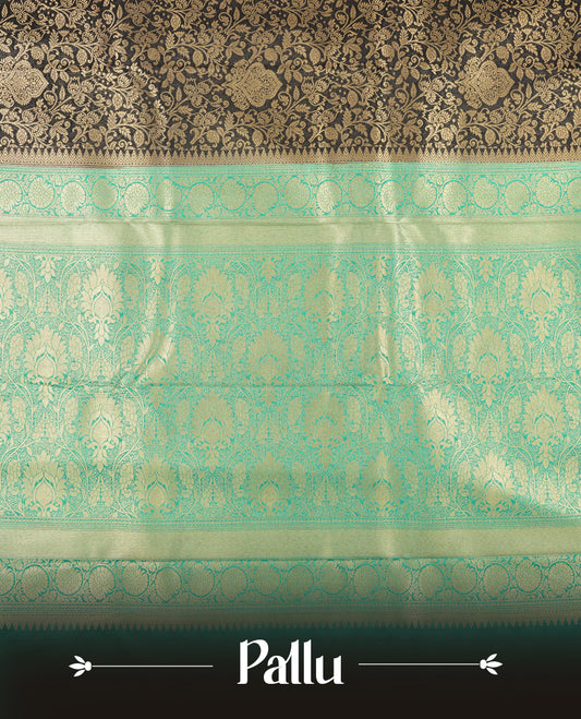 Dark Blue colour semi silk brocade saree featuring intricate Gold Floarl kodi patterns across the body, complemented by a contrast rich Aqua green colour woven border and pallu, paired with a matching blouse.