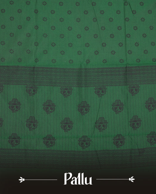 Green colour poly cotton saree with black floral butti motifs on the body, paired with a matching pallu featuring black ornate floral jaal and stripes on the border, and a coordinated all‑over black paisley printed blouse piece. (Copy)