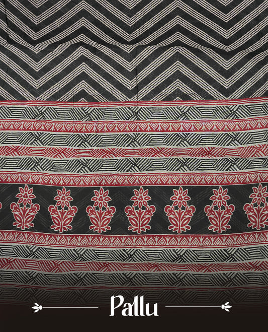 Black colour mixed chanderi cotton saree with ashy white zari body, red and black geometric pallu with floral motifs, gold border, and matching black blouse.