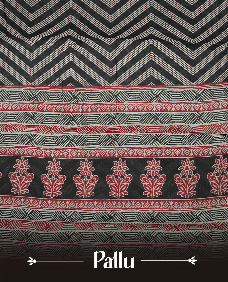Black colour mixed chanderi cotton saree with ashy white zari body, red and black geometric pallu with floral motifs, gold border, and matching black blouse.
