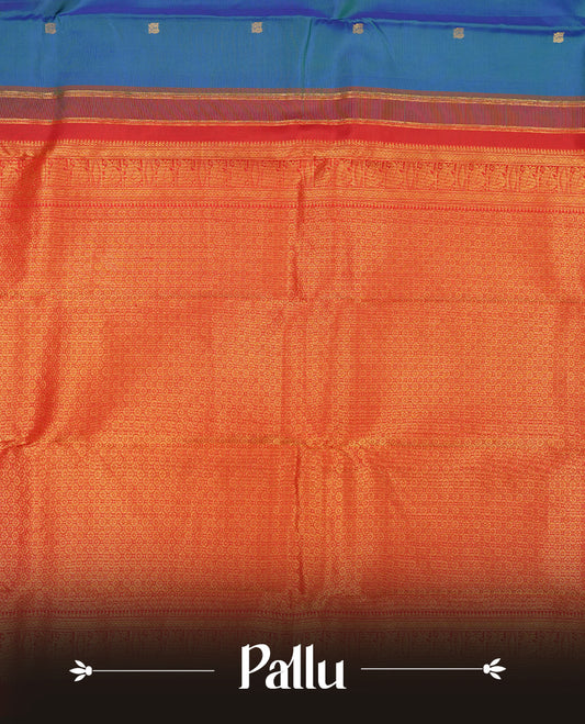 Peacock colour Vasundhara silk saree adorned with all-over gold mayil motifs on the body, complemented by a contrast red colour with gold traditional with mayil pattern border and paired with a matching blouse piece.