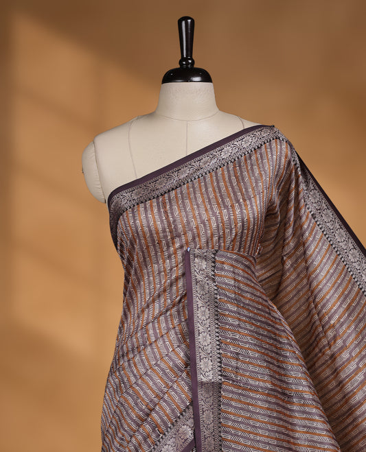 Cream colour chanderi silk saree with purple & yellow geometric stripped printed On body, compilmented by contrast Dark purple colour border with golden zari floral pattern and a matching blouse.