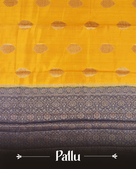Golden Yellow Colour Banaras Soft Silk Saree with Gold Zari Oval Leaf Buttas, Intricate Multi-Layered Floral Border, Grand Pallu with Ornate Brocade Motifs in Navy Blue and Gold Tones, and Matching Blouse.