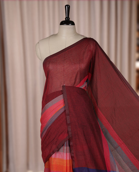 Maroon colour soft cotton saree with rainbow colored horizontal lines on the body, a vibrant multicolor pallu, and a subtle border & Elegant and lightweight, this saree comes without a blouse piece for a customizable style.