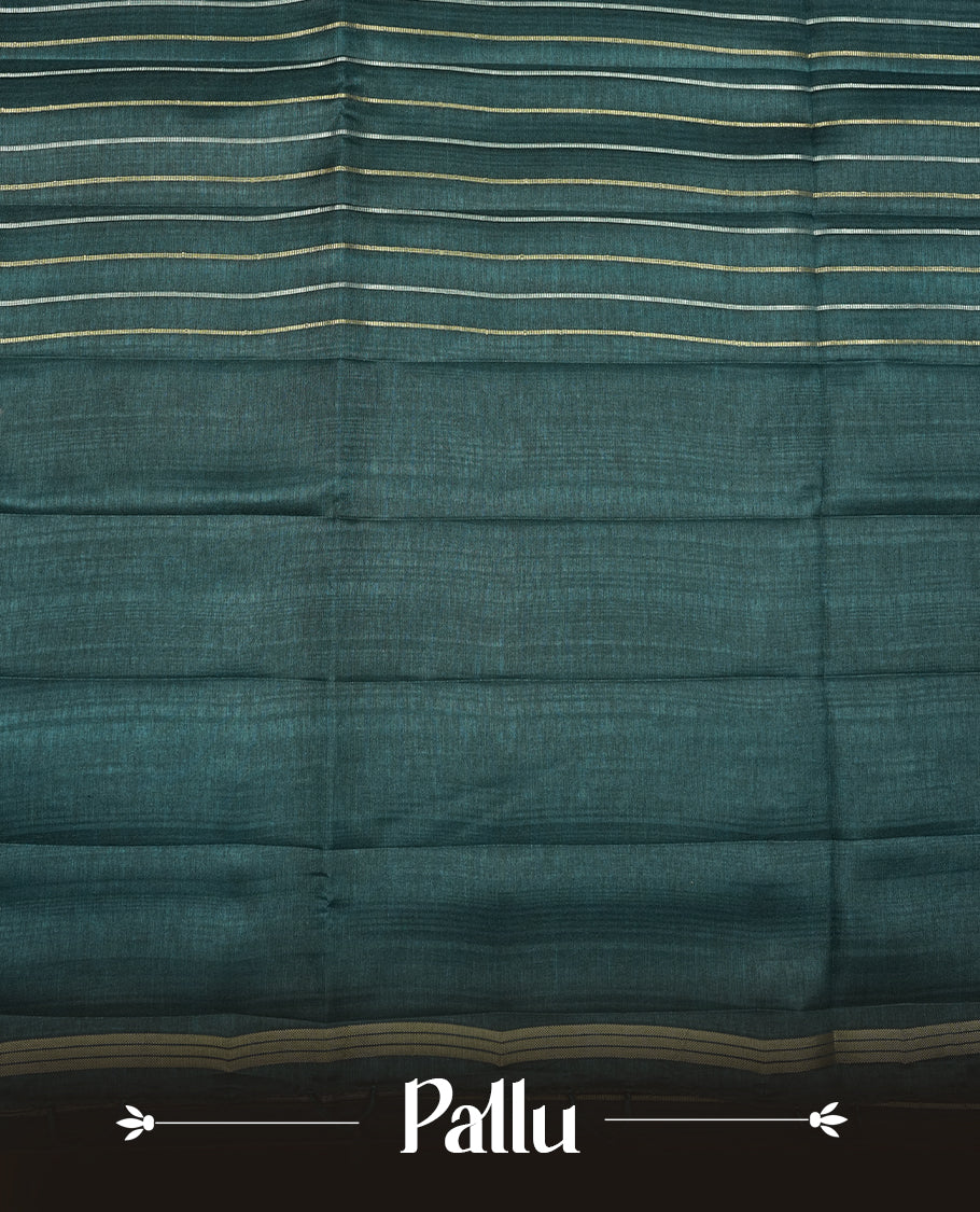 Teal colour semi tussar silk saree highlights gold and silver zari stripes across body,  border, pallu and paired with matching blouse piece.