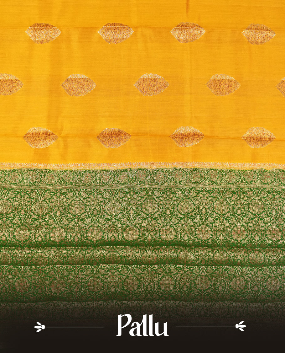 Golden Yellow Colour Banaras Soft Silk Saree with Gold Zari Textured Oval Buttas, Simple Decorative Pallu Border, Grand Pallu with Ornate Floral and Foliate Motifs in Green and Gold Tones, and Matching Forest Green Blouse.