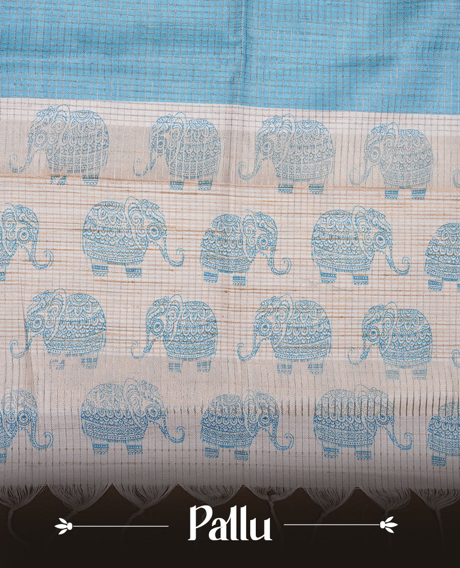 Sky-blue and off-white colour semi tussar silk saree featuring an all-over elephant motif print across the body, complemented by a contrasting blue pallu and border, and paired with a matching blouse piece.