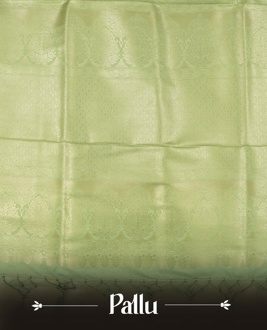 Light Green colour semi soft silk saree featuring an all-over woven leaf pattern in gold colour, finished with a matching border adorned with detailed paisley and floral motifs, and a matching blouse piece.