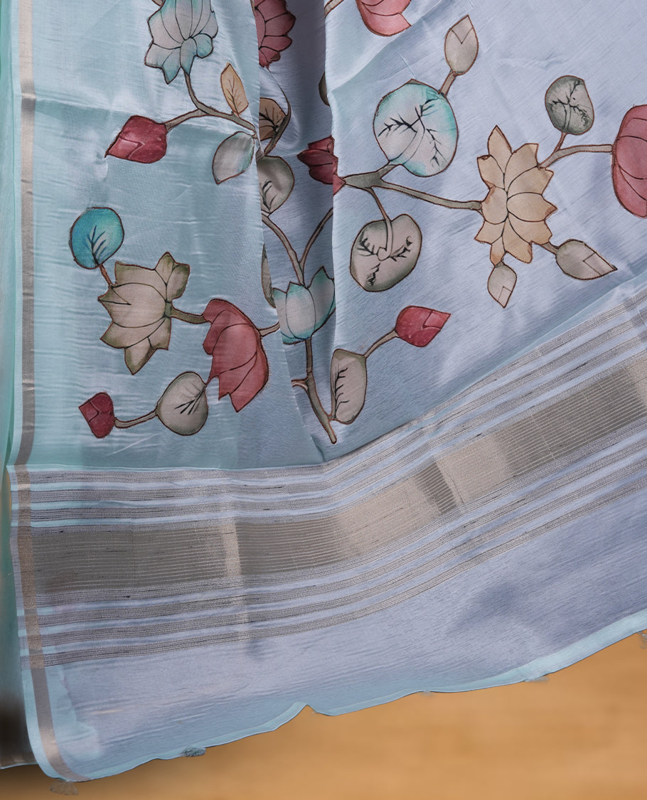 Light aqua blue colour semi tusser silk saree featuring delicate hand painted floral motifs along the pallu and border finished with subtle tassels and paired with a matching blouse.