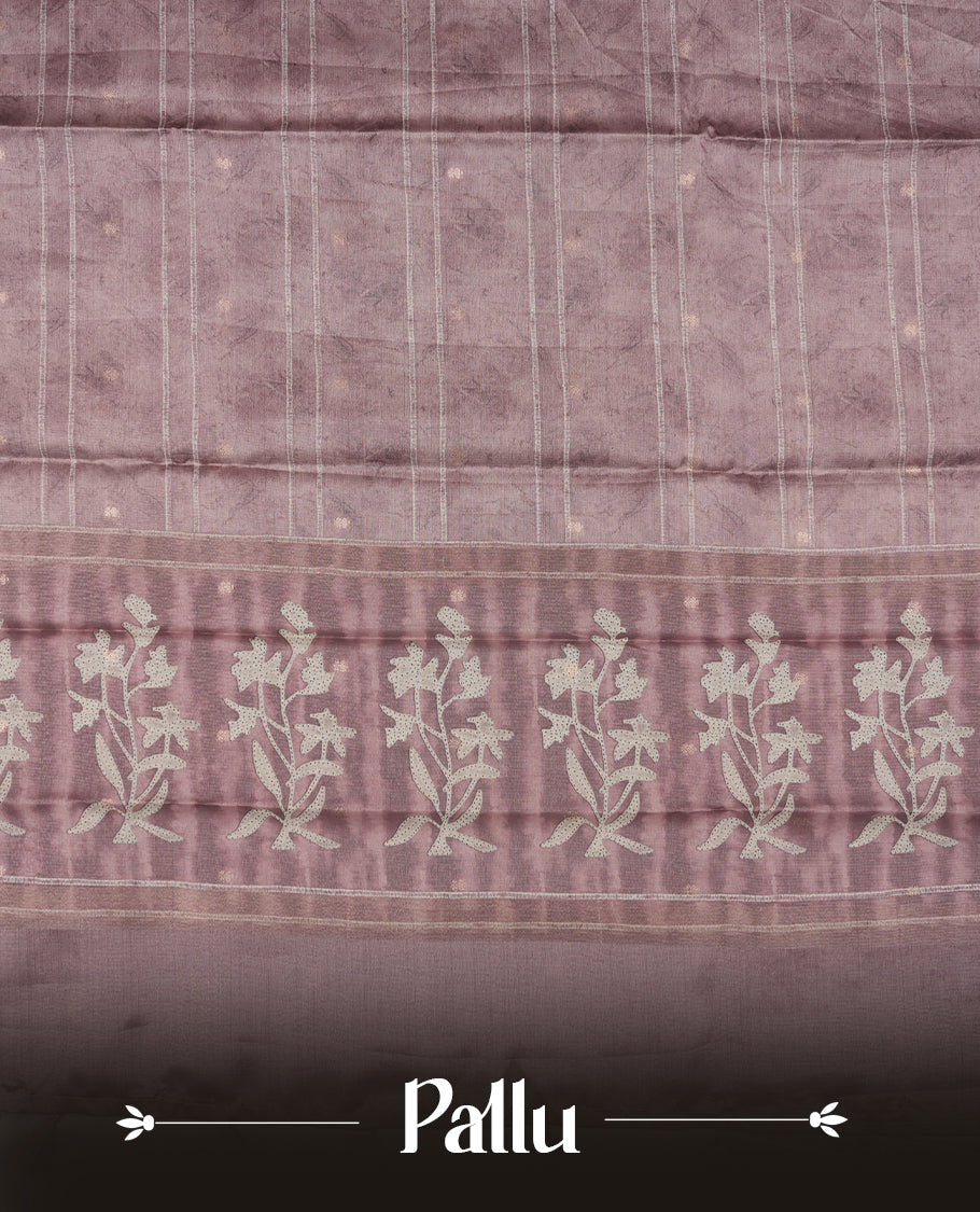 Light Rose copper colour semi tussar saree adorned with Cream strip printed pattern across the body and Floral pattern contrast rose copper colour on border, paired with a matching blouse.