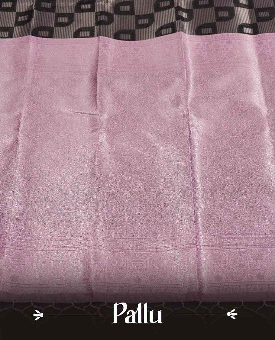 Black colour semi silk saree adorned with silver zari designs on the body, complemented by a contrasting light pink border and pallu, and paired with a matching blouse piece