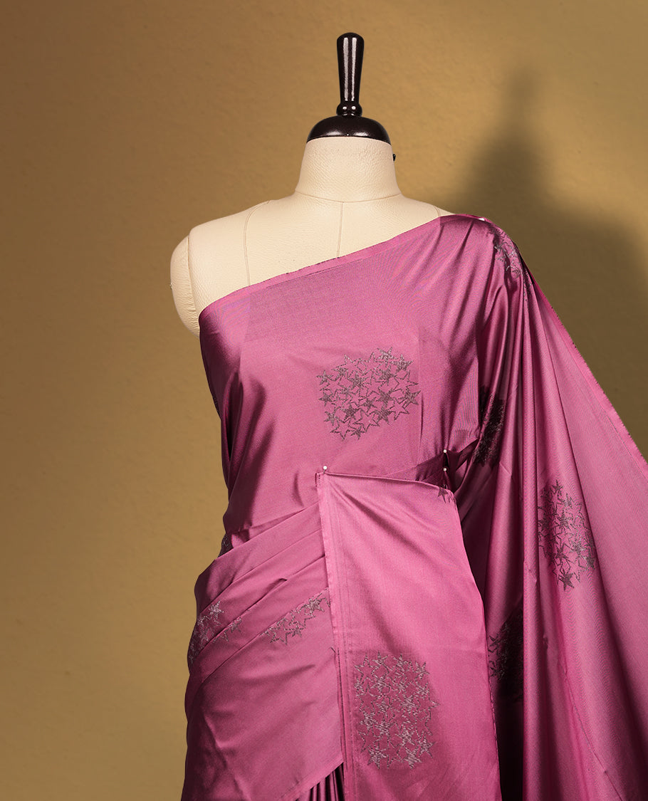 Dark mauve colour semi soft silk saree adorned with delicate woven floral motifs on the body, complemented by a rich contrast deep chocolate colour woven pallu with intricate detailing and tassel accents. Comes with a matching blouse piece