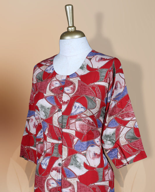 Red colour kurti featuring a round neckline with button detailing, 3/4th sleeves, and an all over floral print in blue and beige, designed in a straight cut silhouette for a simple and elegant everyday look.