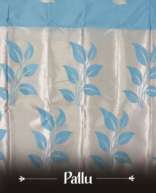 Sky blue colour semi silk saree adorned with elegant floral motifs on the body, complemented by a shimmering golden zari-woven pallu and border, and paired with a matching blouse