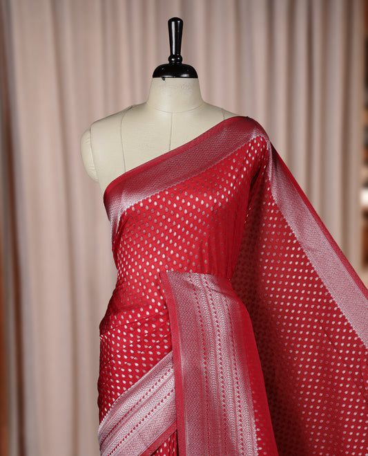 Maroon colour Banarasi silk saree featuring intricate zari weaving and a soft silk texture, Adorned with silver motifs on the body, complemented by a rich Banarasi border and pallu & Comes with a matching blouse.