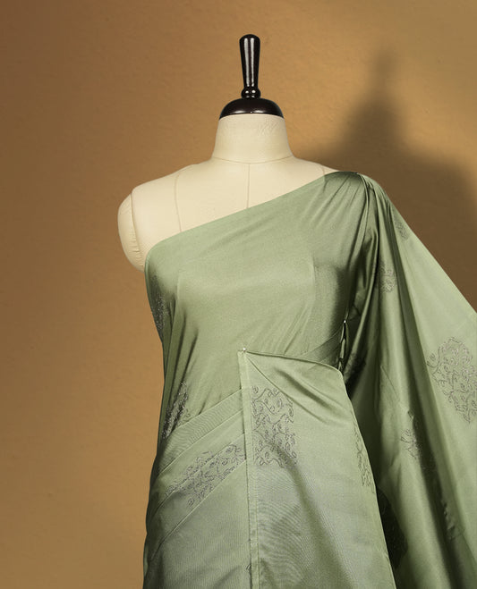 Pastel green colour semi soft silk saree, adorned with subtle self woven motifs on the body & The design is elevated with an elegant zari border and dark chocolate colour pallu, paired with a matching blouse.