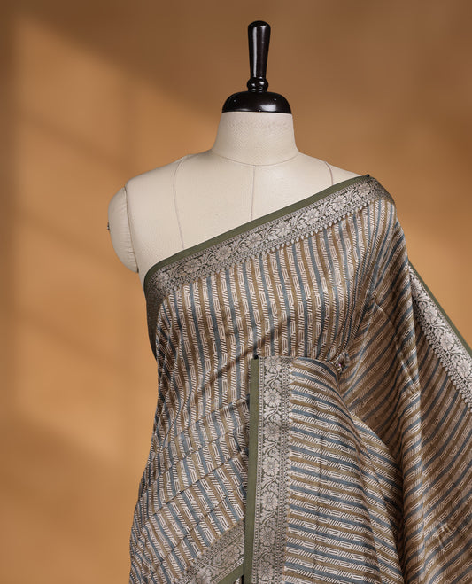 Cream colour chanderi silk saree with Olive & blue geometric stripped printed On body, compilmented by contrast olive colour border with golden zari floral pattern and a matching blouse.
