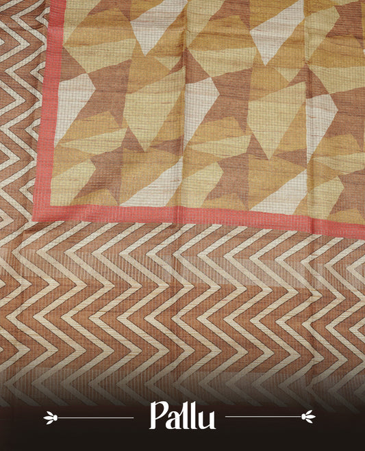 Rust brown colour semi tussar silk saree featuring bold zigzag geometric prints across the body, highlighted with a contrasting coral-red border and detailed pallu, paired with a matching printed blouse piece.