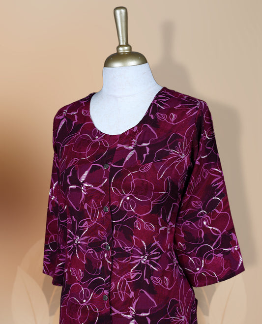 Magenta colour kurti featuring a round neckline with button detailing, 3/4th sleeves, and an all over floral print in pink and beige, designed in a straight cut silhouette for a simple and elegant everyday look.