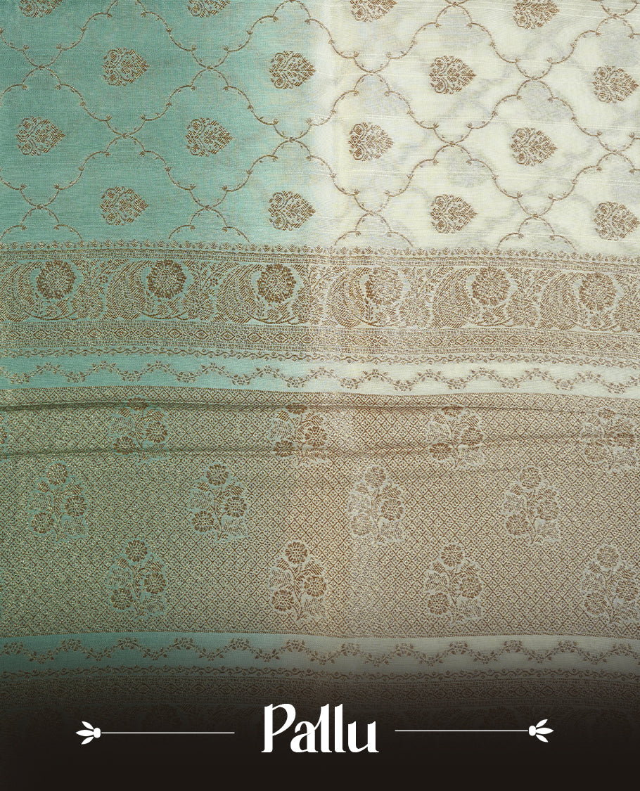 Cream colour semi tussar Banarasi saree featuring Antique zari motifs on body, paired by contrast pastel green colour border, and a matching blouse piece.