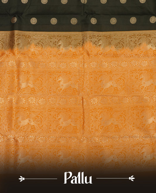 Black colour Vasundhara silk saree adorned with all-over gold chakkaram motifs on the body, complemented by a contrast turmeric colour with gold flower kodi motifs border and paired with a matching blouse piece.