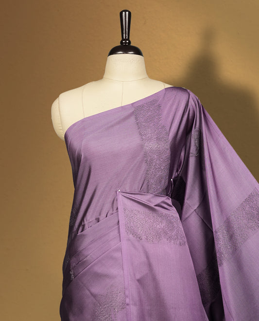 Royal purple colour semi soft silk saree adorned with delicate woven floral motifs on the body, complemented by a rich contrast deep blue colour woven pallu with intricate detailing and tassel accents & Comes with a matching blouse piece.