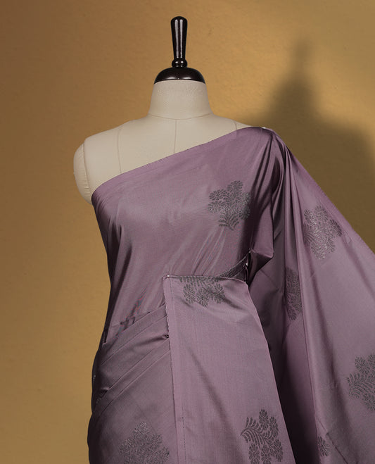 Greyish lavender colour semi soft silk saree, beautifully designed with rich floral woven motifs & The look is enhanced by a rich contrast deep wine border and pallu with tassels, paired with a matching blouse.