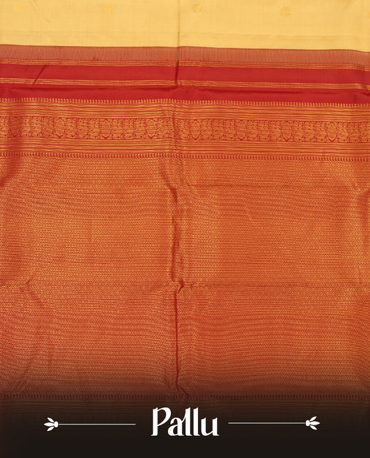 Cream colour Vasundhara silk saree adorned with all-over gold chakkaram & mayil motifs on the body, complemented by a contrast maroon gold tarditional border and paired with a matching blouse piece.