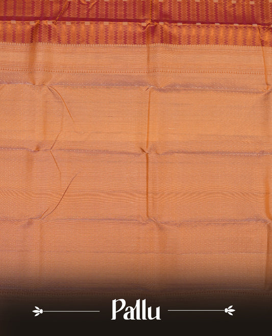 Burnt orange colour Vasundhara silk saree adorned with all-over purple zigzag motifs on the body, complemented by a self colour with gold line pattern border and paired with a matching blouse piece.