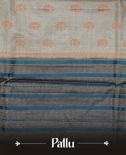 Golden Cream Colour Banaras tussar silk saree featuring Antique zari Motifs on body, Complemented by Blue colour variant with zari border, paired with matching blouse Piece.