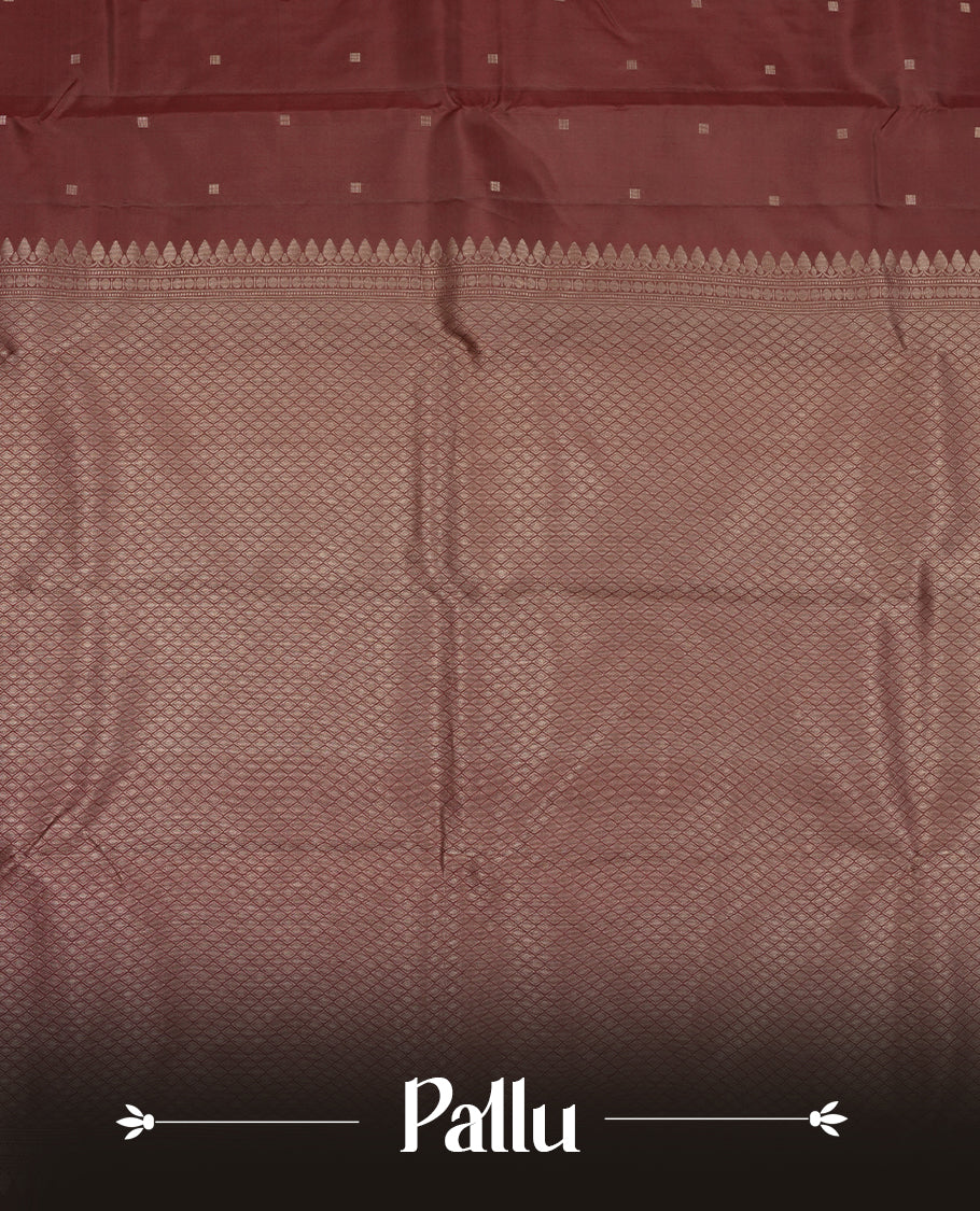 Dark maroon colour Vasundhara silk saree adorned with all-over tiny gold square motifs on the body, complemented by a self colour zari border and paired with a matching blouse piece.