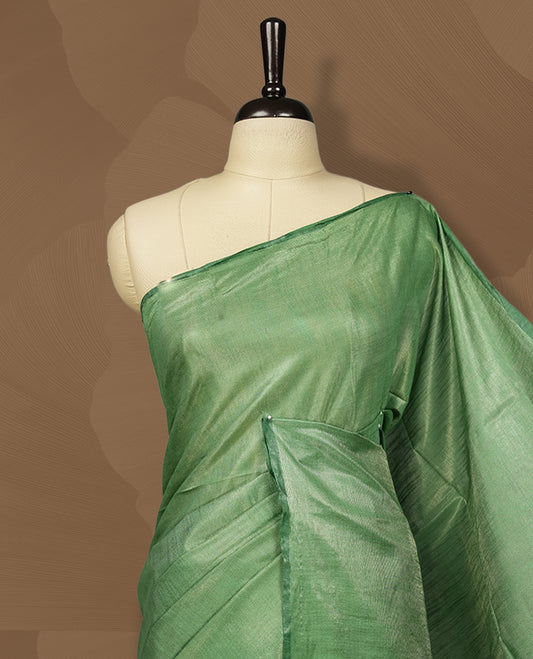 Pastel green colour semi jute tissue saree featuring subtle self weave patterns across the body, complemented by a delicately designed pallu with intricate geometric motifs & Comes with a matching blouse piece for a complete look.