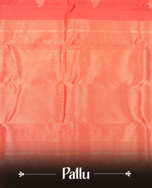 Reddish peach colour Vasundhara silk saree featuring Gold zari motifs across the body, finished with a self‑coloured traditional border and a coordinating blouse.