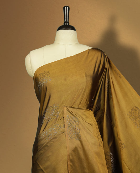 Dark mustard colour semi soft silk saree, adorned with subtle self woven motifs on the body & The design is elevated with an elegant zari border and dark chocolate colour pallu, paired with a matching blouse.
