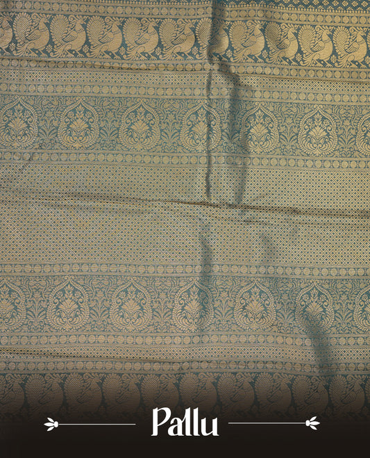 Teal colour semi soft silk saree featuring gold zari motifs on across body, self colour border with traditional gold zari pattern, pallu and paired with matching blouse.