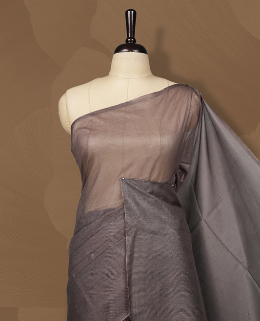Grey brown colour semi jute saree featuring fine striped body work for a subtle texture, Accented with a geometric woven purple shaded pallu, sleek border, soft drape, and a matching blouse piece for a complete look.