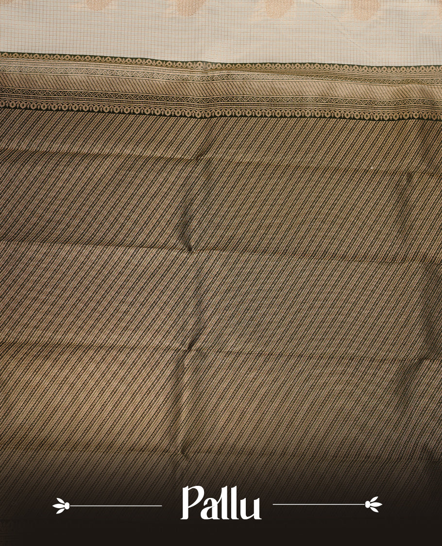 Cream coloured soft silk saree featuring gold zari stripes and motifs across the body, enhanced with a contrast Deep green border and pallu, paired with a matching contrast blouse piece