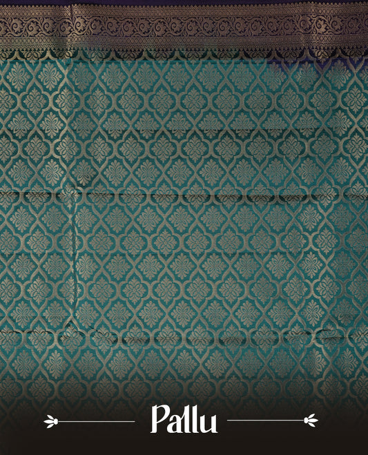 Purple colour soft silk saree featuring gold zari floral motifs on the body, complemented by a contrast green traditional zari floral kodi border and pallu, paired with a matching blouse piece.