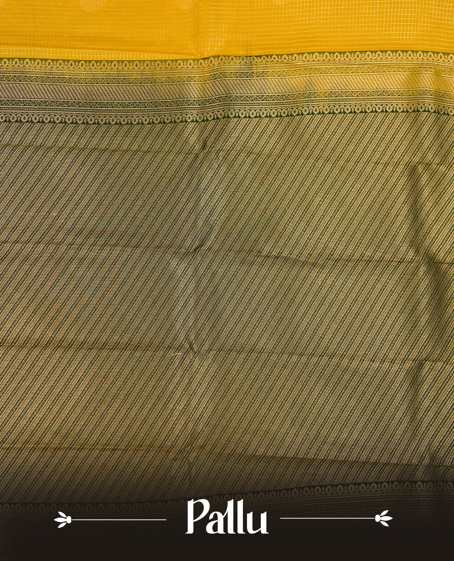 Mustard coloured soft silk saree featuring gold zari stripes and motifs across the body, enhanced with a contrast Dark green border and pallu, paired with a matching contrast blouse piece.