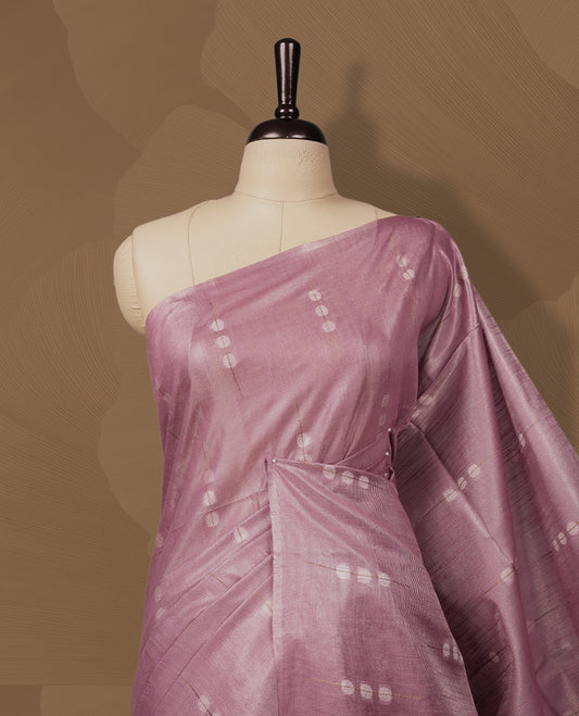 Soft Mauve colour semi jute tissue saree adorned with delicate dotted motifs all over, Features a finely woven pallu and sleek borders for a refined look & Comes with a matching blouse piece.
