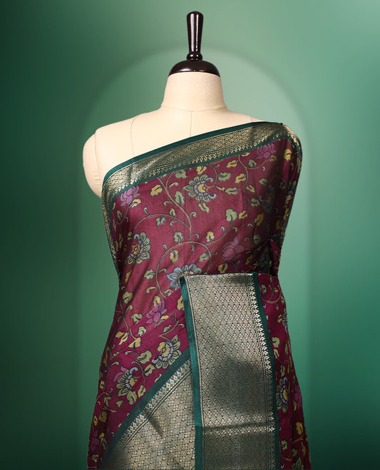 Rich Grape colour saree featuring intricate floral prints across the body, highlighted with a woven Green zari border, complemented by an artistic Kalamkari inspired pallu design, and paired with a matching blouse