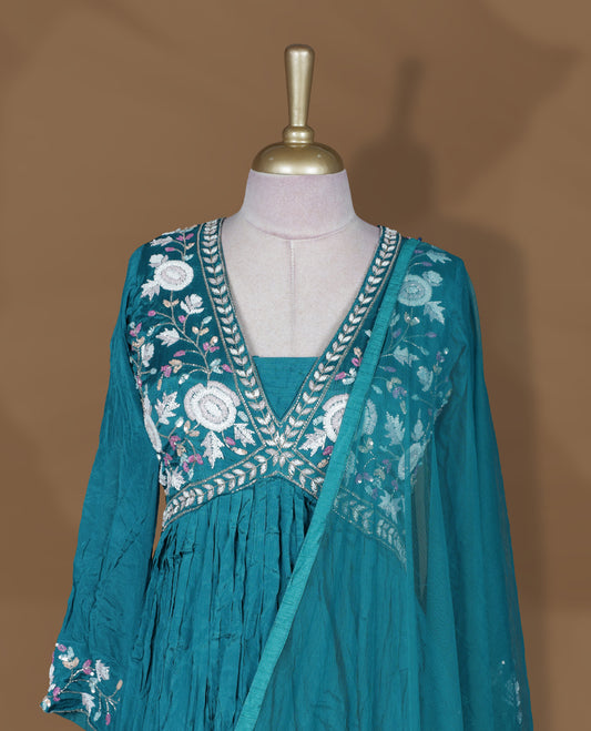 Teal green colour stitched gown set with V‑neck floral embroidered yoke, gathered flare, full sleeves with cuff embroidery, and matching plain sheer dupatta.