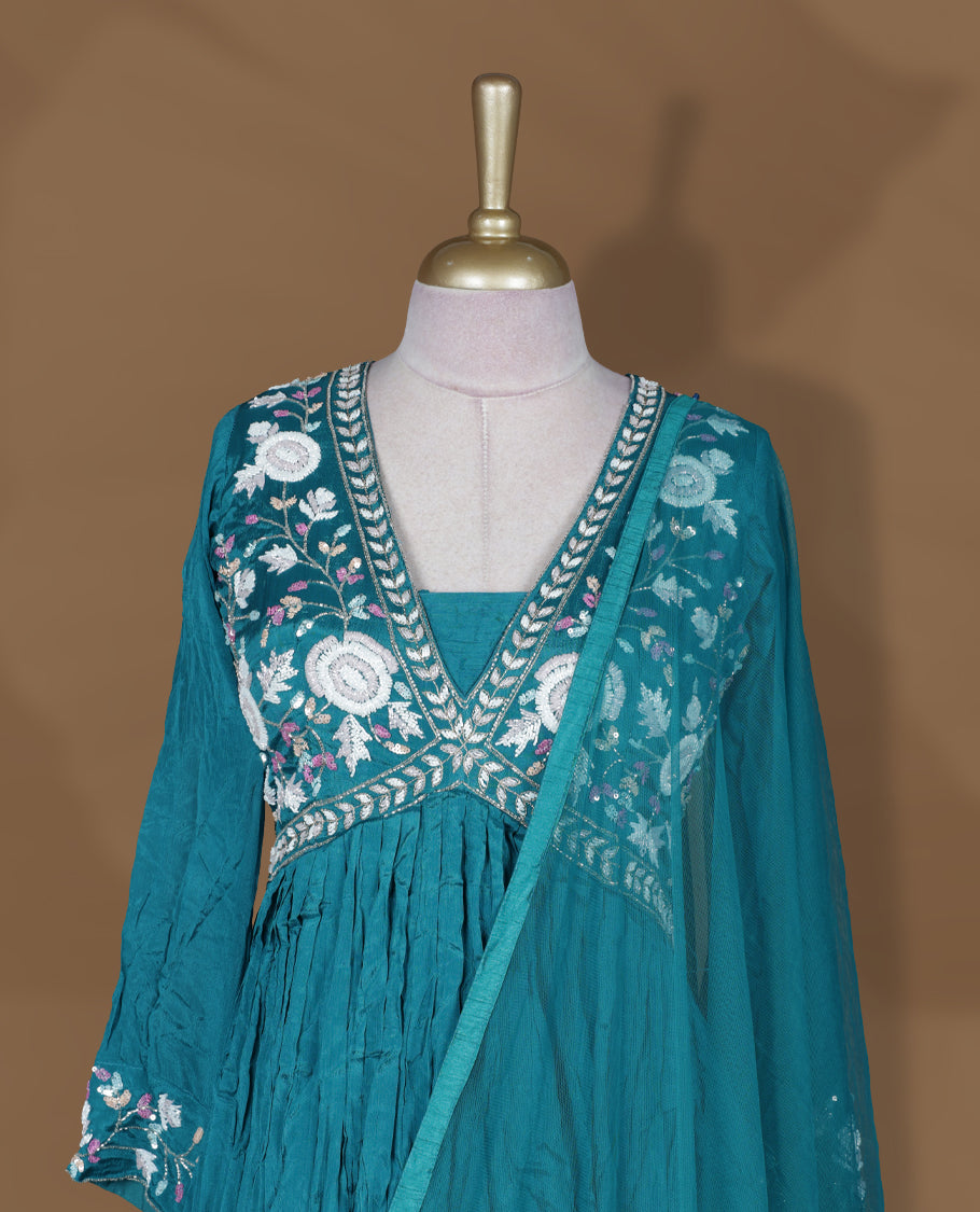 Teal green colour stitched gown set with V‑neck floral embroidered yoke, gathered flare, full sleeves with cuff embroidery, and matching plain sheer dupatta.