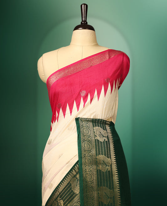 Off white colour saree with delicate golden motifs, highlighted by a striking pink upper border, rich green zari woven border, and a contrasting red and green pallu with intricate floral and geometric designs, paired with a matching blouse