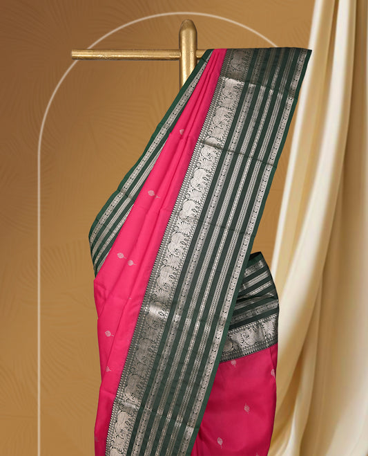 Pink and green colour soft silk saree with rich silver zari border and buttas, paired with a matching blouse.